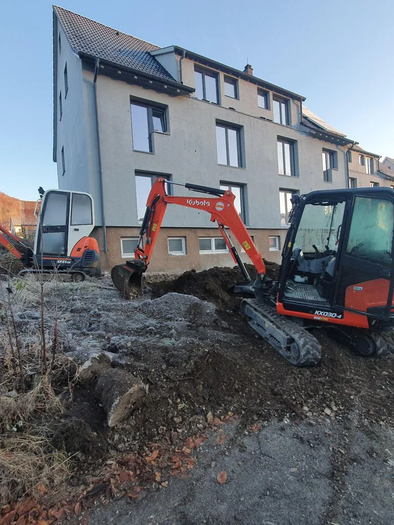 Minibagger der Topal GmbH bei Erdarbeiten vor einem Mehrfamilienhaus